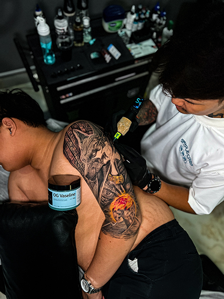 a person getting a tattoo on their back